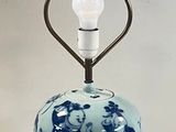 a blue and white vase with a light on it
