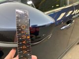 a person holding a ruler in front of a car