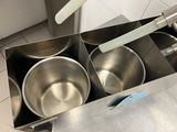 stainless steel pans and utensils sit in a stainless steel box