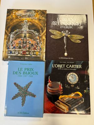 several books are sitting on a table with a clock in the background