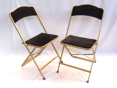 une paire de chaises pliantes en métal doré sur fond blanc
