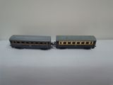 two toy trains sitting side by side on a white surface