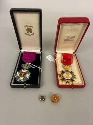 Deux médailles se trouvent dans un écrin rouge et une médaille d'or se trouve dans une boîte noire