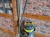 a vacuum that is sitting on the floor in front of a brick wall