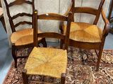 trois chaises et un tabouret sont posés sur un tapis dans une pièce