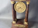 une horloge posée sur une table à côté d'un ventilateur