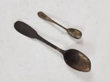 two spoons and a spoon rest on a white surface