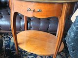 une petite table avec un plateau en marbre posée sur un tapis