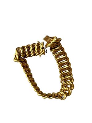 gros plan d'un bracelet en or sur fond blanc
