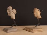 two sculptures of a woman and a man on a table