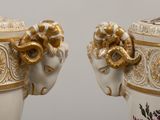 two vases that are decorated with gold and white designs