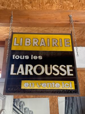 a sign hanging from the ceiling of a library