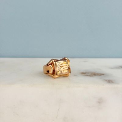 une photo d'une bague en or posée sur un comptoir en marbre