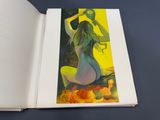 an open book with a painting of a woman sitting on a chair