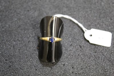 a gold ring with a blue stone on top of it