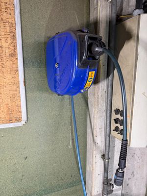 une pompe à eau bleue fixée au mur près d'une fenêtre