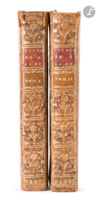 two old books sitting on top of each other on a white surface