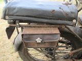 an old motorcycle with a suitcase on the back of it