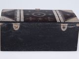 an old black trunk with a metal handle and a wooden lid