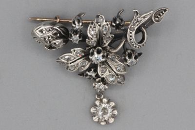 une broche en argent ornée de pierres noires et blanches