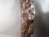 a wooden sculpture of a woman holding a child