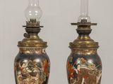 pair of vases on a table with candles on top of them