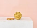a gold coin sitting on top of a marble block
