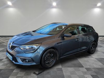 une voiture grise est garée dans une pièce au sol à carreaux