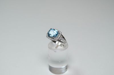 a close up of a ring with a blue topaz stone in it