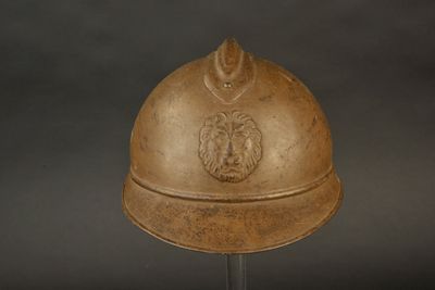 un casque orné d'un lion, posé sur un socle