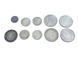 many different types of coins on a white surface