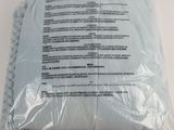 a close up of a pillow on a white surface with a label on it