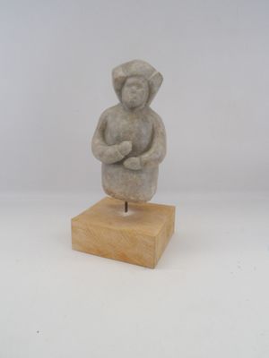 statue d'un homme aux bras croisés, posée sur un socle en bois