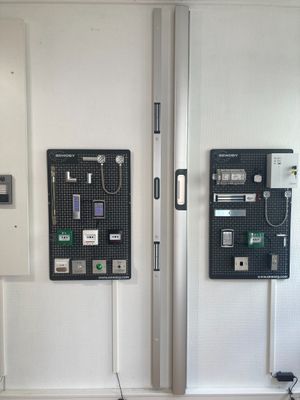 two telephones on the wall next to each other