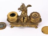 brass figurine of a woman sitting on a boat with a compass