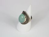 a close up of a ring with a green stone on it