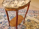a small table with a marble top on a rug