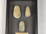 three pieces of stone in a shadow box on a white surface