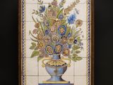 painting of a vase of flowers on a stand with a black background