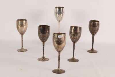 six silver goblets are lined up in a row on a white surface