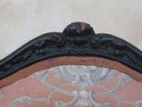 a close up of a chair with a pink upholstered back