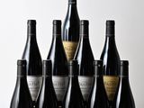 six bouteilles de vin sont alignées sur une table en bois