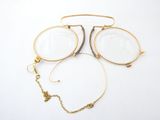 two pairs of glasses and a necklace on a white surface