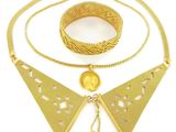 un gros plan d'un collier et d'un bracelet en or sur fond blanc