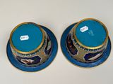 pair of blue and gold vases sitting on top of a white table