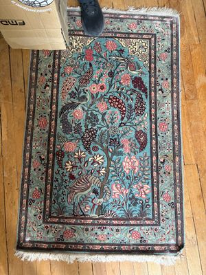 un tapis posé par terre, à côté d'une boîte et d'une paire de chaussures