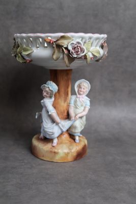 deux figurines d'enfants assis sur un socle