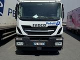 un camion blanc garé sur un parking à côté d'autres camions