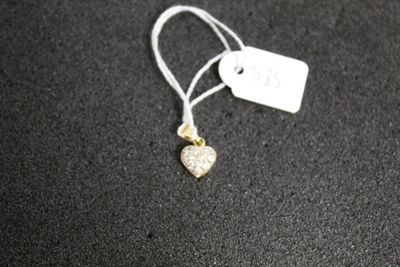un petit pendentif en forme de cœur doré sur un fond noir