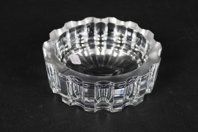 un cendrier en verre transparent posé sur une surface noire